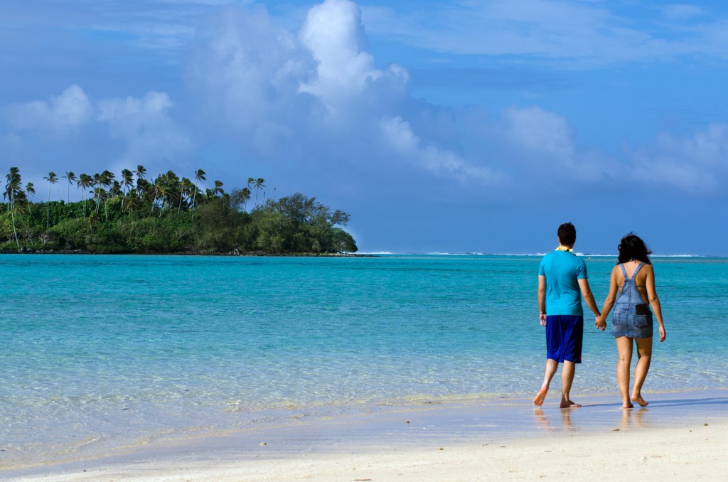 honeymoon couple walking on a beach in the South Pacific